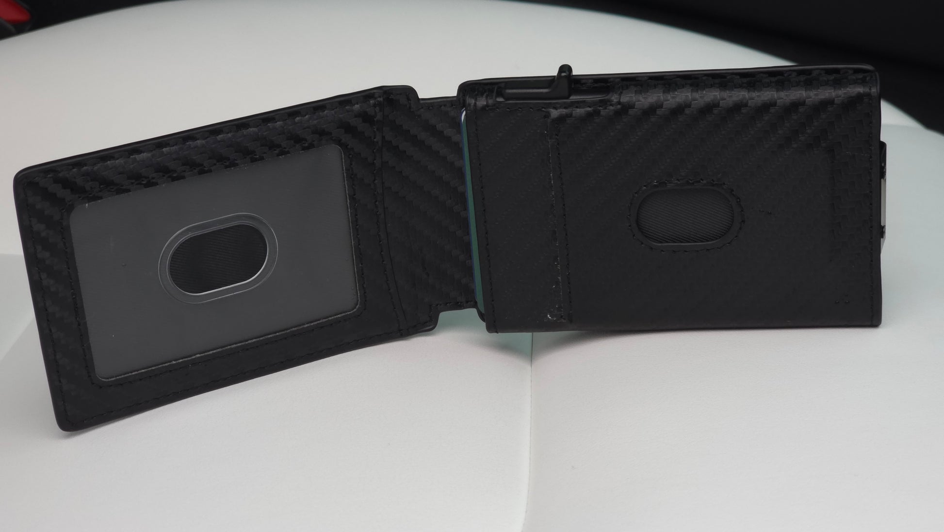 Altus EDC minimalist wallet displaying the unique quick-flip ID window feature for instant verification, alongside the automotive-grade carbon weave finish and 12-card chamber capacity, staged on a white luxury vehicle seat.